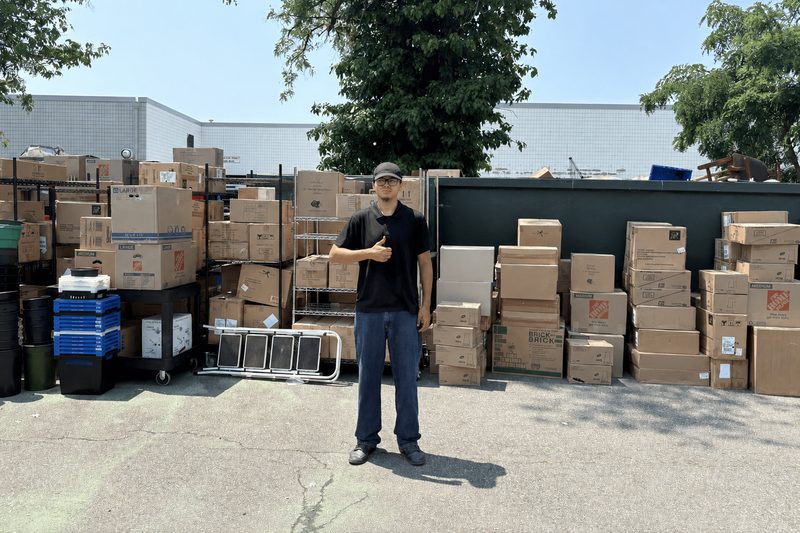Move It Clear It owner standing in front of moving boxes and equipment